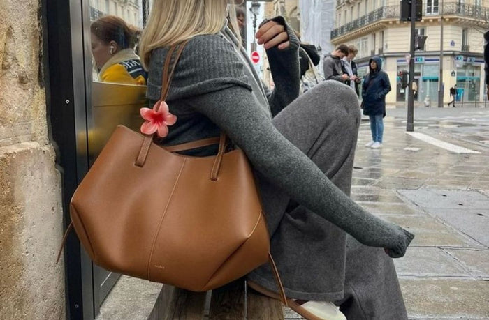 wwomen sitting down wearing leather tote bag 