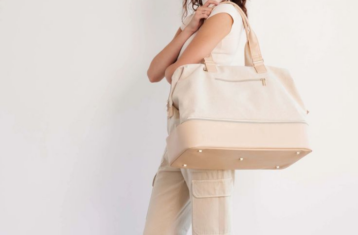 women carrying beis weekender bag in beige