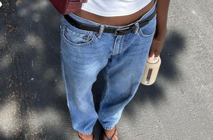 lady wearing light baggy jeans with white tank top and belt